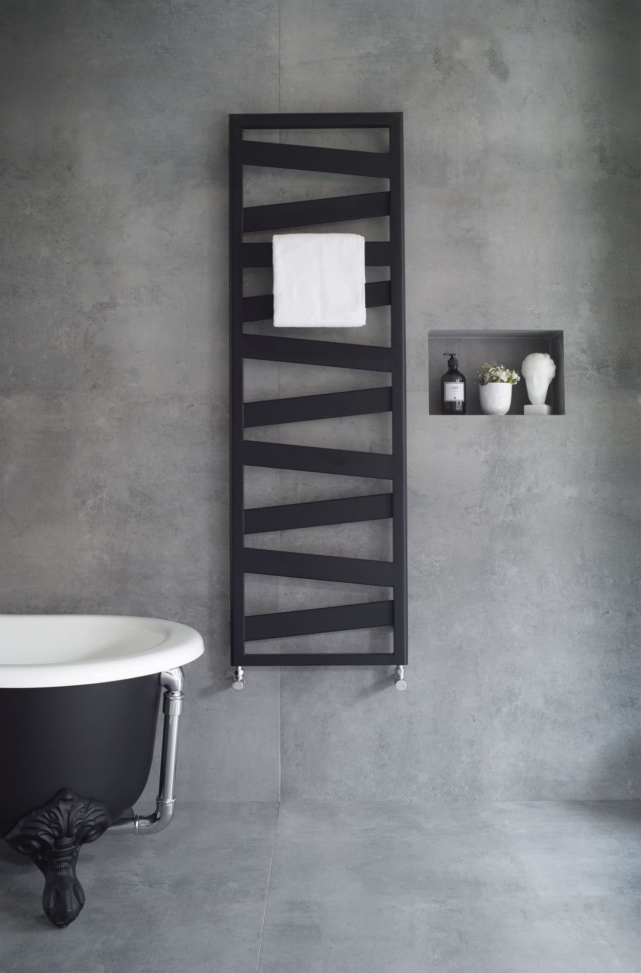 Zehnder Design Heizkörper an grauer Wand mit stylischer Wanne Highlights BadeWelten